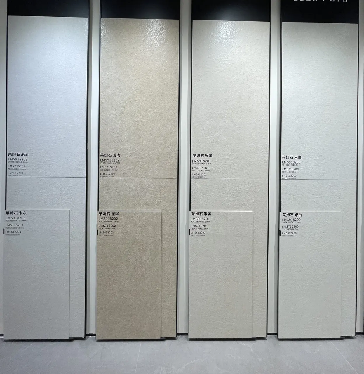 Four labelled limestone-look surface sample boards photographed on a showroom display.