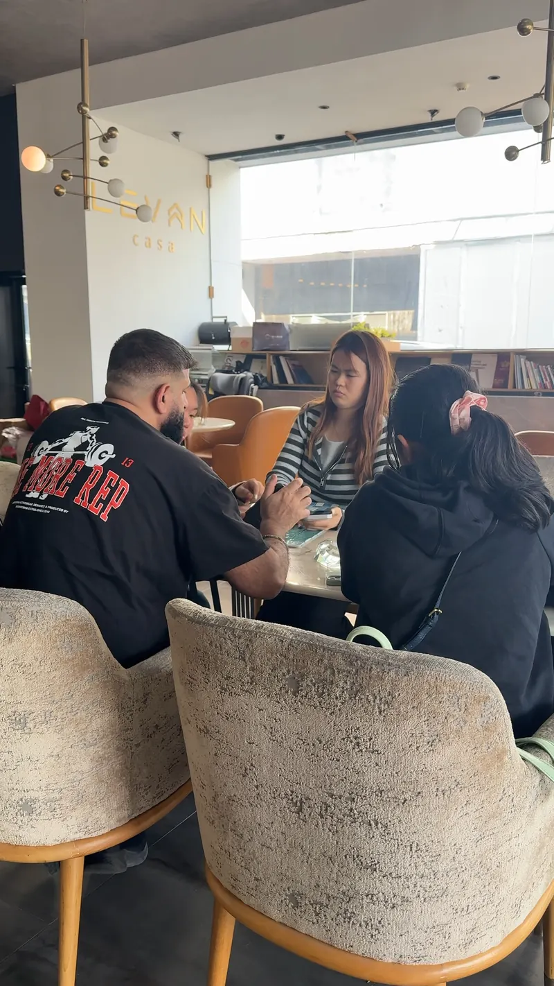 People sit together at a small table with a phone and a flat sample or brochure in front.