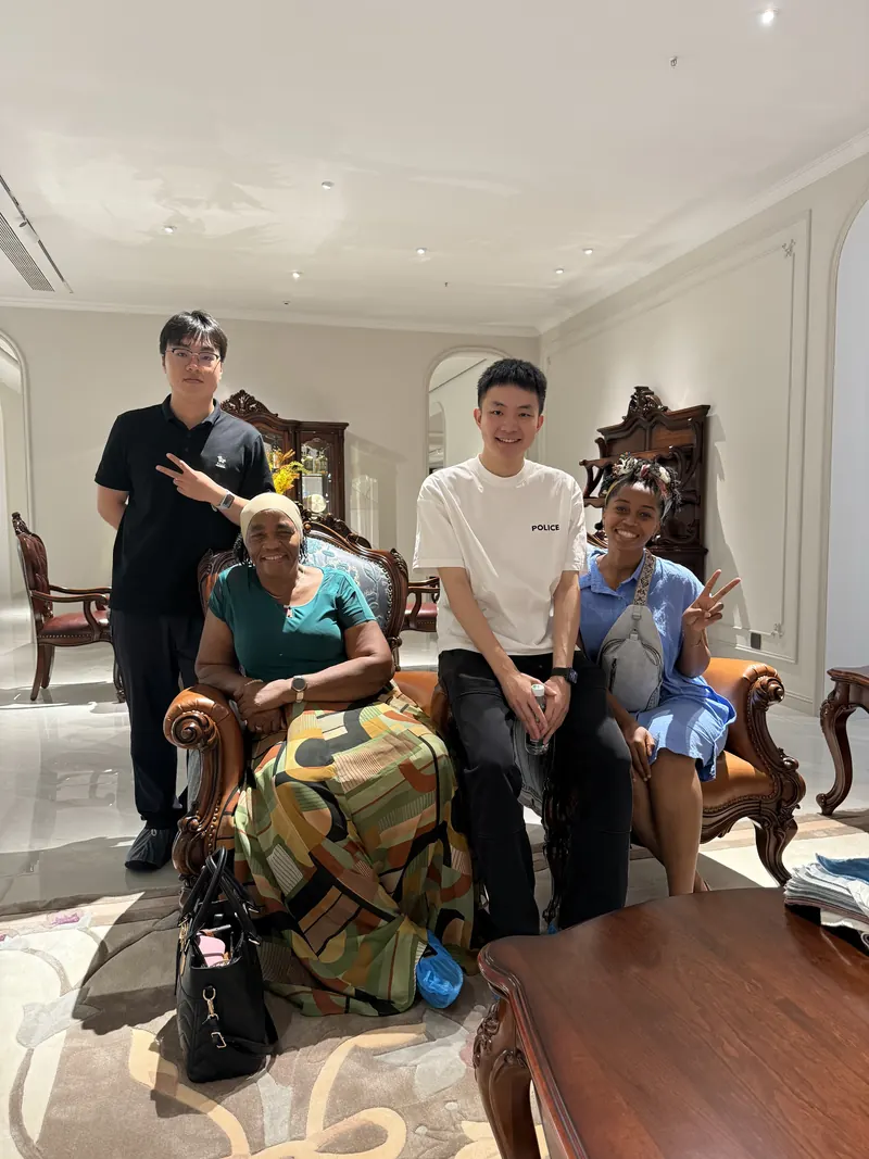 Four adults pose together around decorative seating in a showroom.